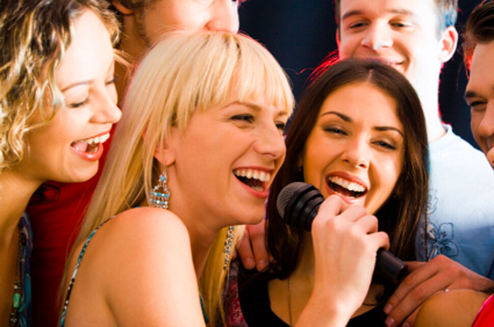 молодые девушки поют в микрофон